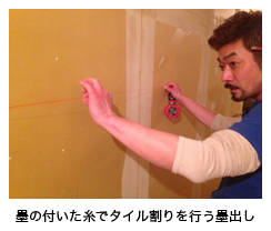 墨の付いた糸でタイル割りを行う墨出し 墨の付いた糸でタイル割りを行う墨出し