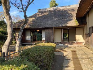 旧但馬家住宅　門から撮影。かやぶき屋根と玄関の奥の窓から見える裏庭の緑が美しい。