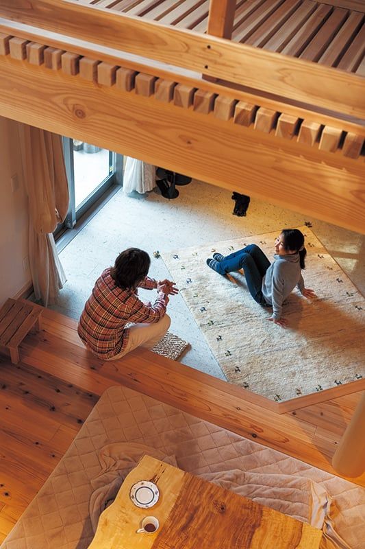 吹き抜けから1階を見下ろす。薪ストーブに合わせて購入したギャッベの絨毯の上は、明子さんのお気に入りの場所。