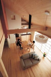 杉板を張った勾配天井の吹き抜けの高さは6ｍ。しっかりとした梁が空間を印象的にしている。障子、窓ガラスは引き込むことができ、ウッドデッキとひと続きになる。