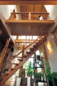 玄関から入ってすぐに、ダイナミックな階段が目に入る。階段下の空間に置かれた観葉植物が来客をやさしく出迎える。