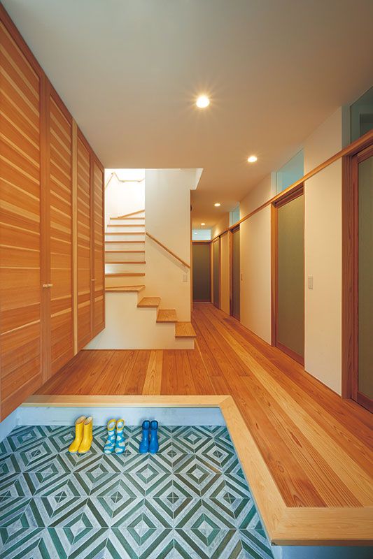 玄関やトイレの個性的なタイルが、木づくりのやさしい風合いにアクセントを添える。