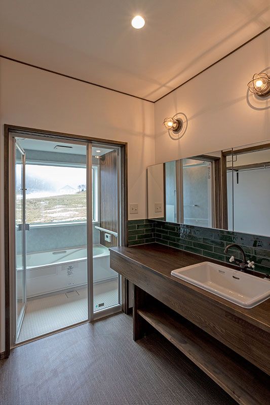 浴室の扉をガラス張りとし、洗面室からも外の景色を楽しめるようにした。マリンランプに遊び心を感じる。
