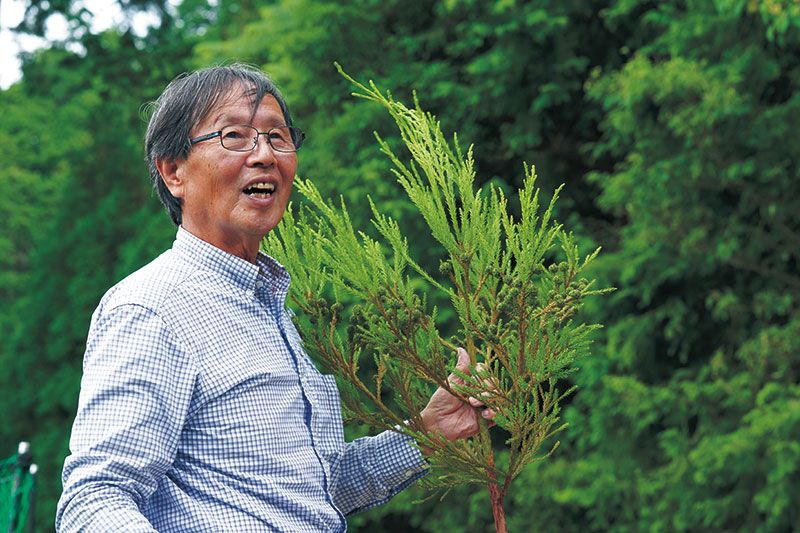 山を案内し木の解説をする田上さん。三代前まで山守りをしていた家系だそう。